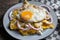 Mexican food: tasty green chilaquiles with fried egg, onion and fresh cheese