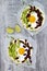 Mexican huevos rancheros tacos. Breakfast tostadas with black beans, avocado, fried egg, microgreens, sriracha ketchup. Top view