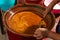 Mexican indigenous woman preparing Mole on a clay pot