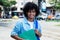 Mexican male student with long curly hair outdoor in city