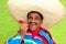 Mexican man poncho sombrero eating red hot chili