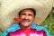 Mexican man poncho sombrero eating red hot chili