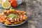 Mexican nachos with beef, guacamole, cheese sauce, peppers, tomato and onion in plate on wood