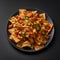 Mexican nachos with chicken, cheese, bell pepper, onion and salsa on black background