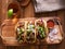 Mexican pork carnitas tacos with beer on wooden tray and radish garnish