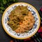 Mexican pork chicharron with green sauce and rice on dark background