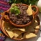 Mexican refried beans with totopos on white background