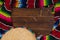 Mexican Sobrero and Serape blanket on wooden background with cop