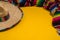 Mexican Sobrero and Serape blanket on yellow background with cop