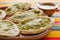 Mexican sopes with grated cheese and green salsa, mexican food spicy in mexico