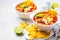 Mexican soup Chili con carne with beans, chicken, corn and nachos in white bowls - traditional mexican food