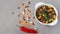 Mexican soup of seven kinds of beans with basil, close-up, on a gray linen background surrounded by red pepper and beans