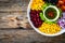 Mexican style salad - red beans, black olives, corn, yellow pepper, onion and tomatoes on wooden table