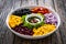 Mexican style salad - red beans, black olives, corn, yellow pepper, onion and tomatoes on wooden table