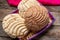 Mexican sweet bread: vanilla and chocolate conchas on wooden background