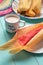 Mexican sweet tamales with strawberry jam on turquoise background