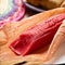 Mexican sweet tamales with strawberry jam on wooden background