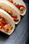 Mexican tacos with pork and vegetables. Al pastor taco on slate tableware. Close up.