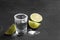 Mexican Tequila shot, lime slices and salt on grey table