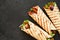 Mexican tortilla grilled wrap with chicken breast and vegetables on concrete background