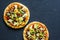 Mexican vegetarian pizza with beans, corn, jalapeno pepper, mozzarella cheese on a dark background, top view.