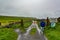 Mexican woman standing next to the gate where the coastal walk route starts from Doolin to the Cliffs of Moher