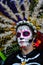 Mexico City, Mexico, ; November 1 2015: Portrait of a woman with colorful hat or penacho in disguise at the Day of the Dead celebr