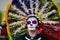 Mexico City, Mexico, ; November 1 2015: Portrait of a woman with colorful hat or penacho in disguise at the Day of the Dead celebr