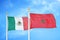 Mexico and Morocco two flags on flagpoles and blue cloudy sky