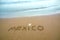 Mexico written on the sand on the beach.