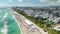 Miami Beach city with high luxury hotels and condos and sandy beachfront. High angle view of tourist infrastructure in