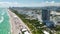 Miami Beach city with high luxury hotels and condos and sandy beachfront. High angle view of tourist infrastructure in