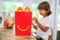 Miami, FL - July 28, 2020: Boy child eating Mcdonalds happy meal burger at home after getting drive-thru lunch during pamdemic