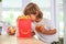 Miami, FL - July 28, 2020: Boy child eating Mcdonalds happy meal burger at home after getting drive-thru lunch during pamdemic