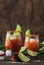 Michelada - Mexican alcoholic cocktail with beer, lime juice, tomato juice, spicy sauce and spices, vintage wooden background,