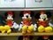 Mickey Mouse - shaped stuffed animals are displayed on the shelves, looking very cute