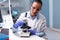 Microbiologist doctor woman analyzing vaccine results using medical microscope