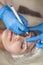 Microblading, Micropigmentation Concepts. Eyebrows Workflow in Beauty Salon for Woman Having Her Eyebrows Drawn and Tinted With
