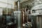 Microbrewery equipment. Close up tanks in brewery warehouse. Metal brewery vessels. Small business concept.