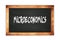 MICROECONOMICS text written on wooden frame school blackboard