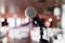 Microphone close-up. Focus on mic. Abstract blurred conference hall or wedding banquet on background. Event concept