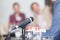 Microphone in focus against blurred people at roundtable event