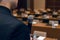 Microphone in hand of man in suit on background of empty conference hall. Rehearsal of public speaking