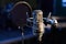 Microphone with a pop shield closeup on the background of a professional recording studio. Microphone stand with a