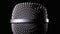 The Microphone Rotates on a Black Background. Dynamic Microphone Grid Spins Close-up