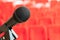 microphone on the stand in an empty assembly hall with red chairs. concept of trainings, business meetings and conferences.