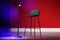 Microphone and stool on stage against color wall