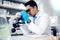 Microscope, Asian man in laboratory for healthcare, science method and research innovation. Male researcher, chemist and