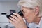 Microscope, doctor and senior woman in laboratory for research, experiment or innovation. Science, biotechnology and