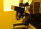 Microscope in laboratory under the yellow light for working with